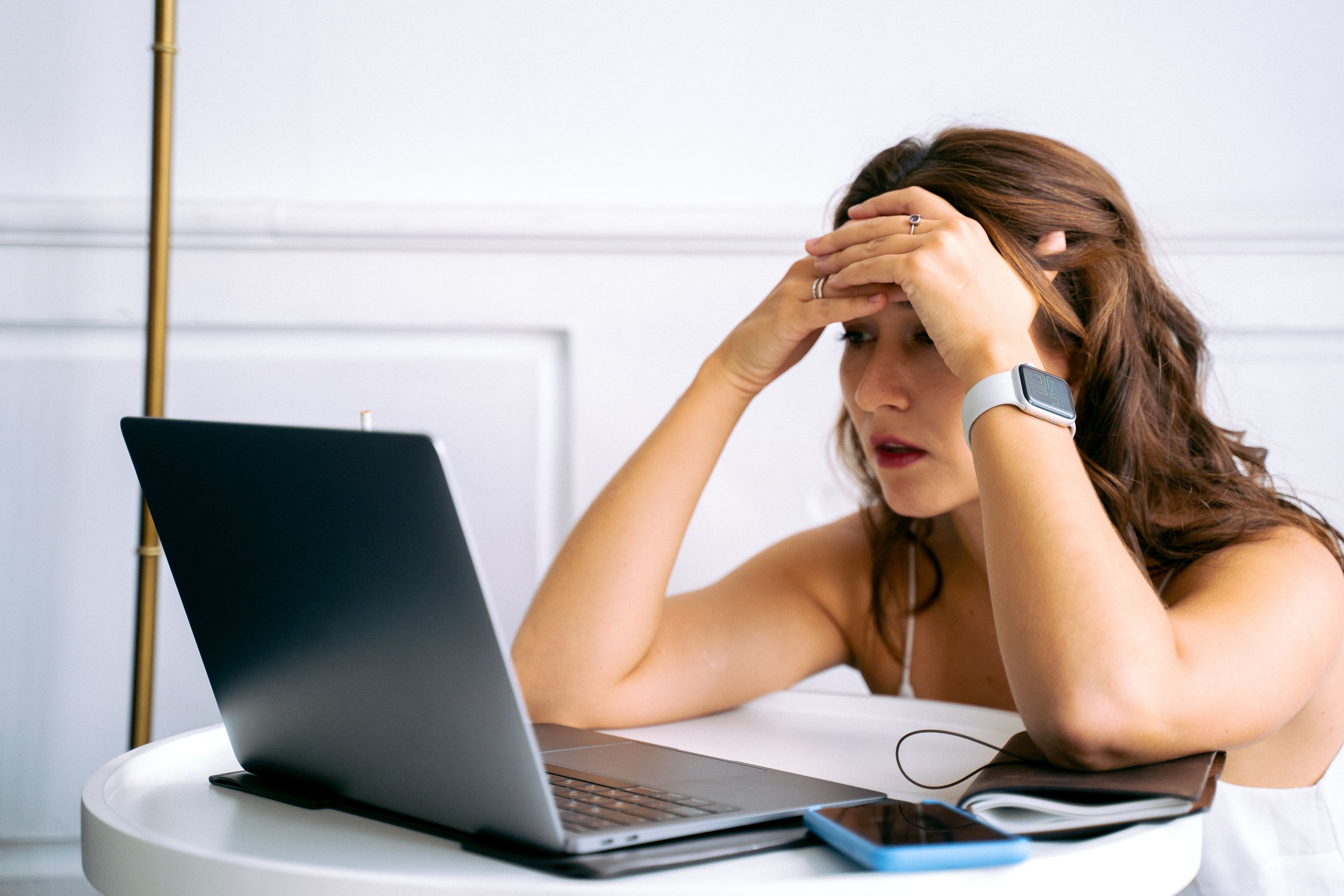 Profesional preocupada mirando su computadora portátil tras sufrir la caída de su sitio web WordPress con error 500